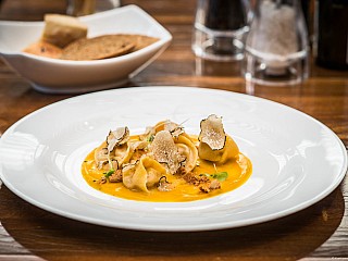 Agnolotti with Black Truffle, Filled with Italian Sausage and Stracchino Cheese, Served on a Pumpkin Cream